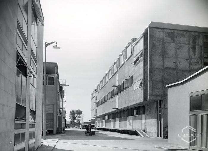 A destra i magazzini sintetici e prodotti chimico-farmaceutici (edificio B7), a sinistra la centrale termica e centrale servizi (edificio B11), inizio anni '60